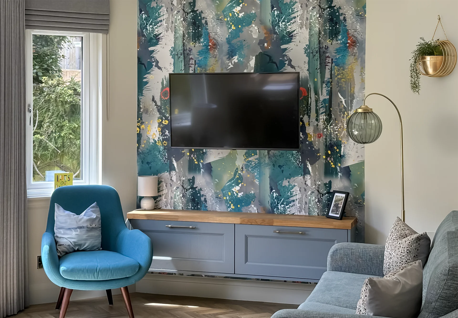 Seating area with a wall-mounted TV and artistic wallpaper