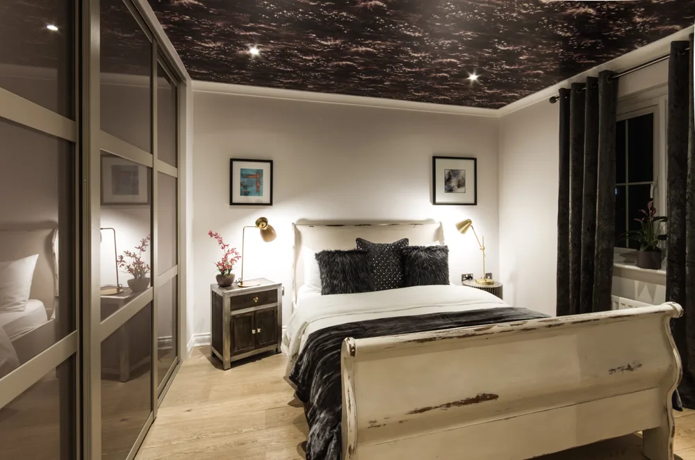 Statement bedroom with feature ceiling and classic sleigh bed